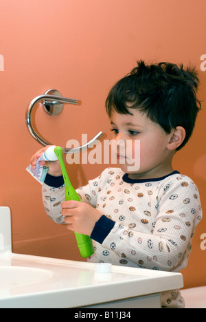 Two and 1/2 year old boy tries to brush his teeth all by himself before he goes to bed