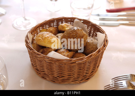 Basket of mixed breads on a restaurant table UK Stock Photo