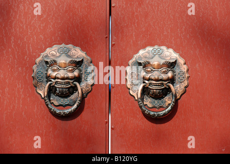 Lion knocker on red door Stock Photo