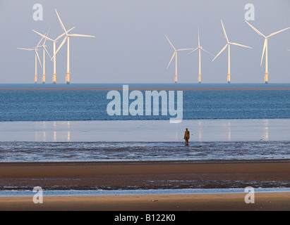 ANTONY GORMLEY SCULPTURED FIGURE  ON BEACH AT CROSBY WITH WINDFARM IN BACKGROUND, , LIVERPOOL, MERSEYSIDE, ENGLAND,UK, Stock Photo