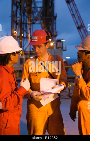 Oil workers discussing the work. Ensco rig. Natuna Field. Sea South China Sea. Indonesia. Stock Photo