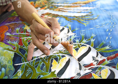 Batik painting closeup hand holding canting Stock Photo