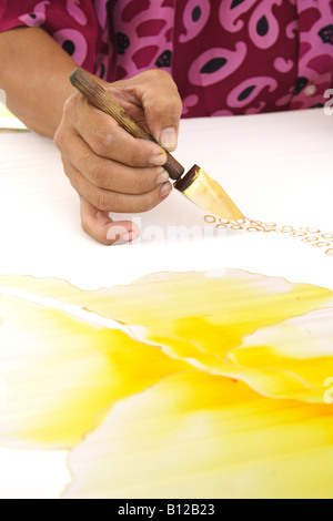 Batik painting closeup hand holding canting Stock Photo