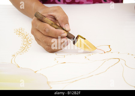 Batik painting closeup hand holding canting Stock Photo