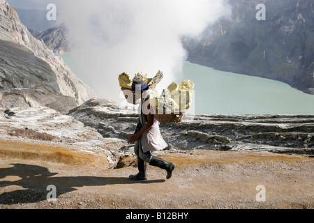 Indonesian man carrying baskets with sulphur, Ijen plateau, East Java, Indonesia Stock Photo