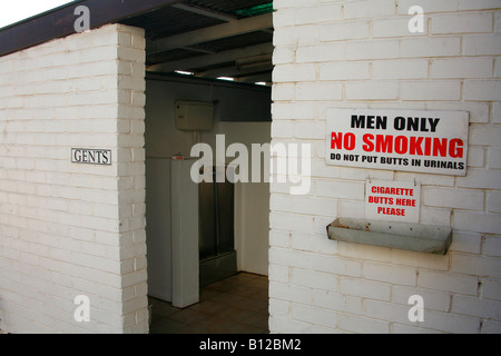 Humorous No Smoking sign outside mens toilet Stock Photo