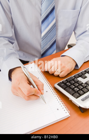Business man writing in a notebook Stock Photo