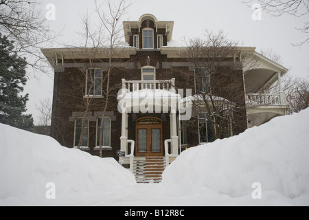 Heaps of snow bank a recently cleared path to a house in Montreal after a heavy snow storm. Stock Photo