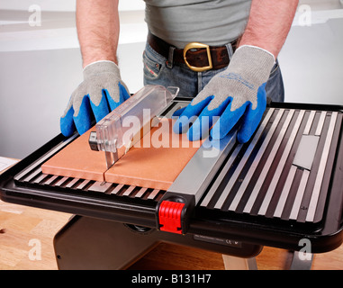 MAN USING MACHINE TILE CUTTER Stock Photo