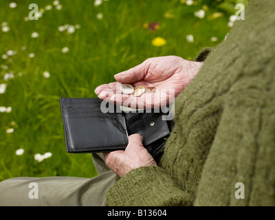 old hands of a senior counting less money in a purse Stock Photo