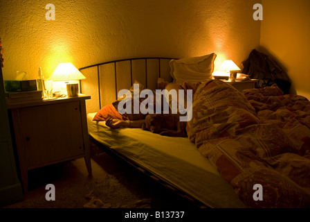 Stock photo of a woman and her puppy asleep in her bed Stock Photo