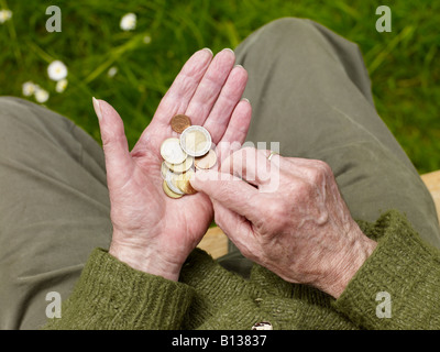 old hands of a senior counting less money, coins Stock Photo