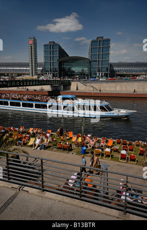 Berlin Hauptbahnhof, Spree, pleasure boat. People relaxing in canvas chairs at beach location Café Restaurant Bar Capital Beach. Stock Photo