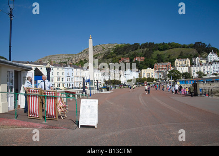 Llandudno Conwy North Wales UK May A couple of men hiring out deck chairs on the wide promenade Stock Photo