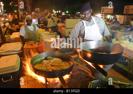 a local chef cook up a fish fry at the Oistins fish market in Bridgetown, Barbados Stock Photo