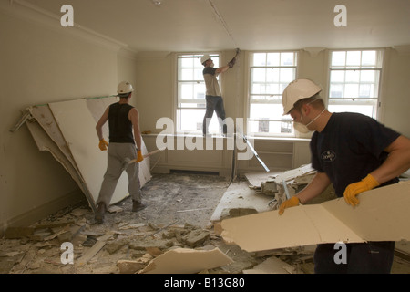 Workers break down a building on a demolition site. Stock Photo