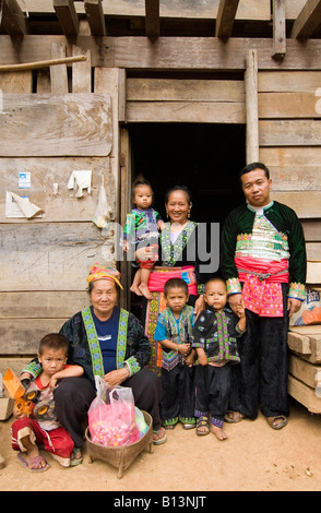 An ethnic Hmong family wear their traditional ethnic Hmong outfits outside their home in the mountains of northern Thailand Stock Photo