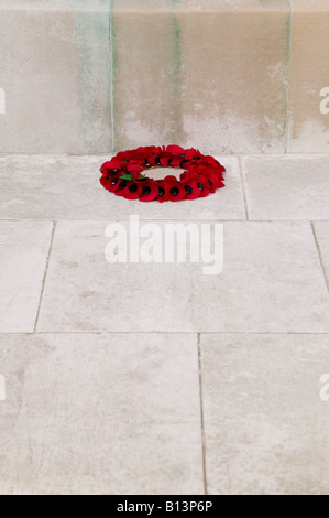 A single poppy wreath at the base of a war memorial on rememberance Sunday Stock Photo