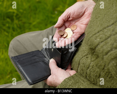 old hands of a senior counting less money in a purse Stock Photo