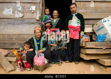 An ethnic Hmong family wear their traditional ethnic Hmong outfits outside their home in the mountains of northern Thailand Stock Photo