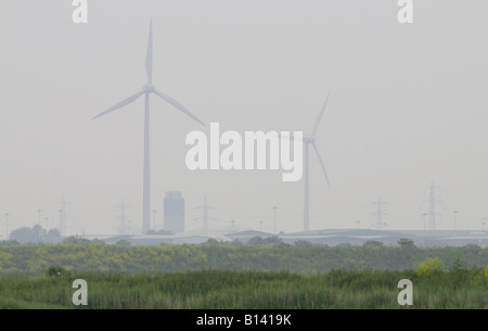 Electricity generating windmills on border of city and countryside Stock Photo