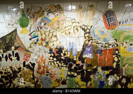 A wall in a train station in Tokyo is decorated with an artistic looking mural. Japan. Stock Photo