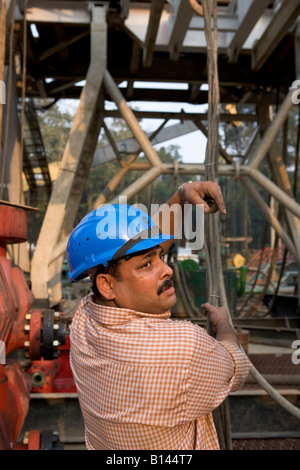 A worker wearing a hard hat on Lakkhi 1 Rig Site near Digboi, Assam, India 2005 Stock Photo