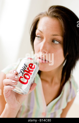 Girl drinking from Cola Can tin Stock Photo