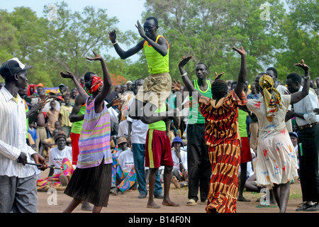 In this photo of traditional Dinka dancing in Rumbek, South Sudan, the women dance, as the men take turns jumping into the air. Stock Photo