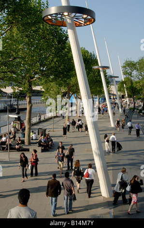 Crowds of people enjoying the late afternoon sun on London's South Bank, beside the River Thames, London, England