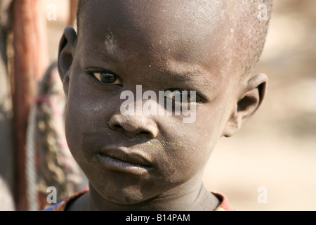Young Dinka boy growing up in a cattle camp.  Traditionally pastoralists, they live in camps with hundreds or thousands of cows. Stock Photo