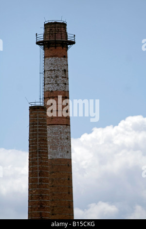 White and red chimney of factory against the sky and clouds. Stock Photo