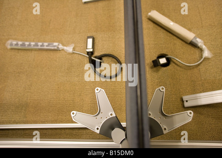 Electric power strips sit underneath partly installed communal desks in a newly constructed office building. Stock Photo