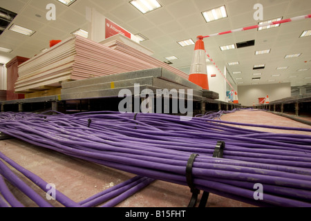 Bundles of cables run through the raised floor of a newly constructed office building. Stock Photo