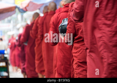 Buddhist monks on their morning alms walk in the center of Yangon Myanmar, Burma Stock Photo