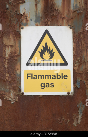 Yellow warning sign for flammable gas on rusty barn door Stock Photo