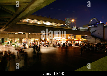 Theatregoers hover outside the entrance of the National Theatre, South Bank, London Stock Photo