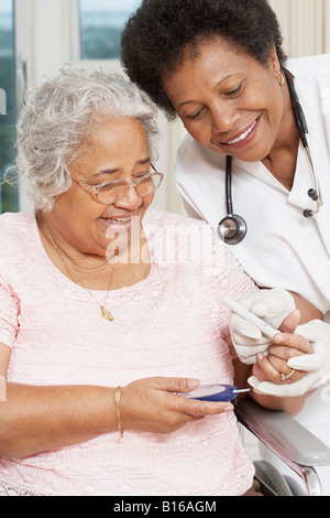 Doctor testing African American woman’s blood sugar Stock Photo