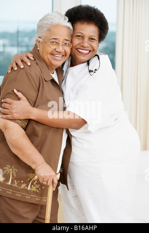 Doctor hugging senior African American woman Stock Photo