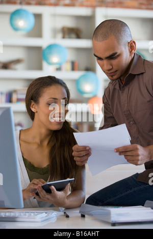 African American couple paying bills online Stock Photo