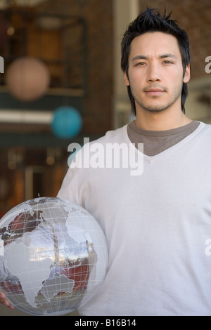 Asian man holding globe Stock Photo