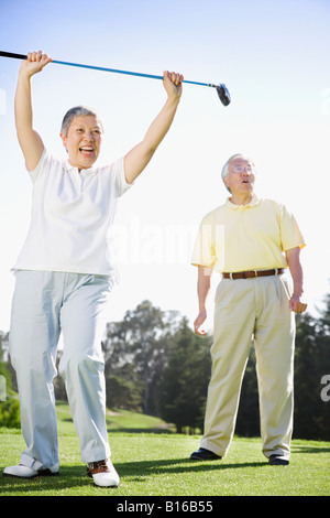 Senior Asian woman cheering on golf course Stock Photo