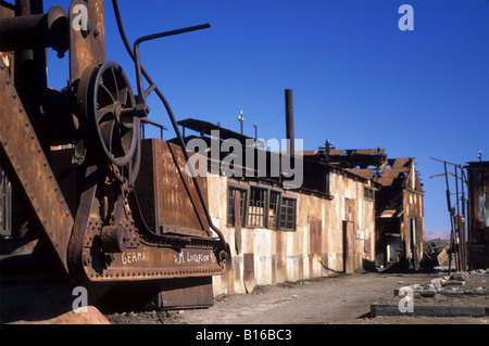 Rusting crane and buildings in the abandoned nitrate mining town of Humberstone, near Iquique, Chile Stock Photo