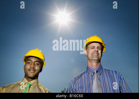 Multi-ethnic businessmen wearing hard hats Stock Photo