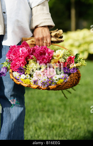 Hispanic woman holding basket of flowers Stock Photo