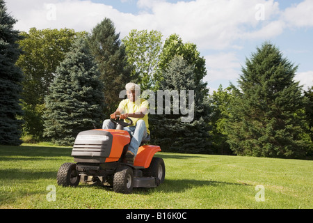 African American man mowing lawn Stock Photo