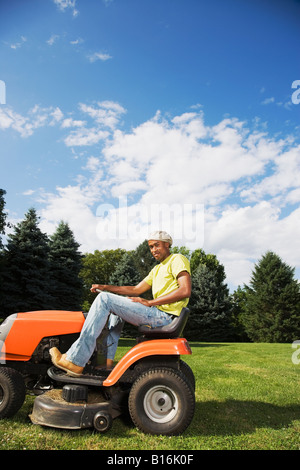 African American man mowing lawn Stock Photo