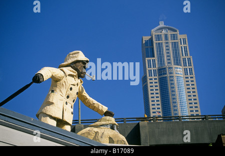 An overview of the Seattle skyline from the waterfront area downtown This is a statue of an old mariner over a restaurant Stock Photo