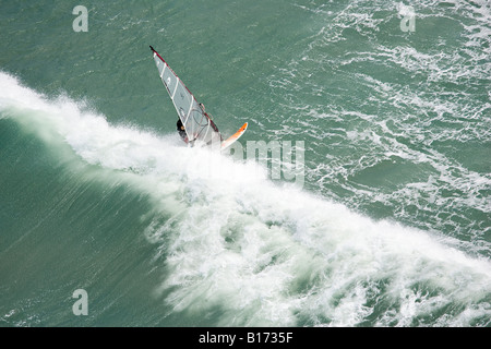 Windsurfer chased by wave Stock Photo