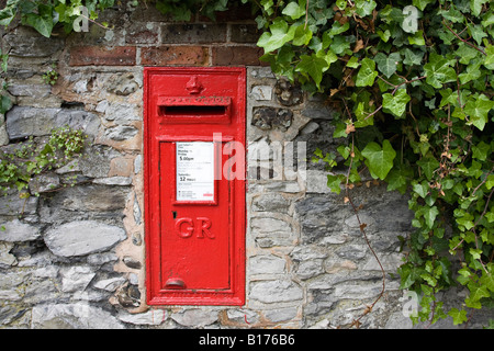 Red post box set into wall. Sussex, England, UK Stock Photo